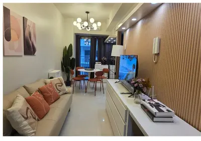 a living room with a couch and a dining room at Posh & Chic Suite 1 Bedroom Mall of Asia Airport in Manila