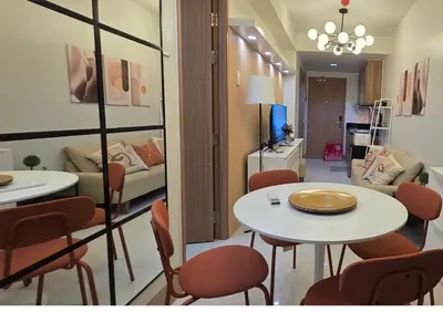 a room with a table and chairs and a living room at Posh & Chic Suite 1 Bedroom Mall of Asia Airport in Manila