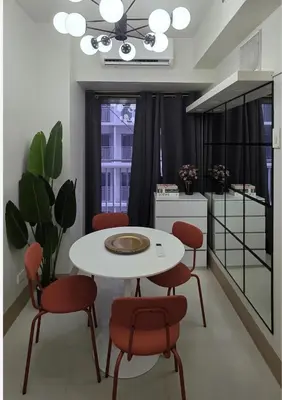 a dining room with a white table and red chairs at Posh & Chic Suite 1 Bedroom Mall of Asia Airport in Manila