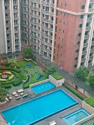 an aerial view of two swimming pools in a city with tall buildings at Self check-in Spacious 1BR near Airport NAIA T3, Mall of Asia in Manila