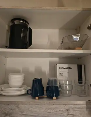 a shelf with bowls and plates and a microwave at Self check-in Spacious 1BR near Airport NAIA T3, Mall of Asia in Manila