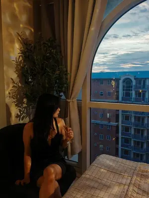 a woman sitting on a couch with a glass of wine at Self check-in Spacious 1BR near Airport NAIA T3, Mall of Asia in Manila