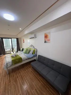 a bedroom with a bed and a couch in it at Sy bay suites Near Ayala mall PITX DFA T3T2 Okada MSV2106 in Manila