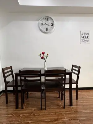 a dining room table with a vase of flowers on it at Sy bay suites Near Ayala mall PITX DFA T3T2 Okada MSV2106 in Manila