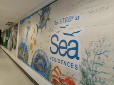a wall with a sign that reads the strip at sea fisheries at Queen Pia Condotel in Manila