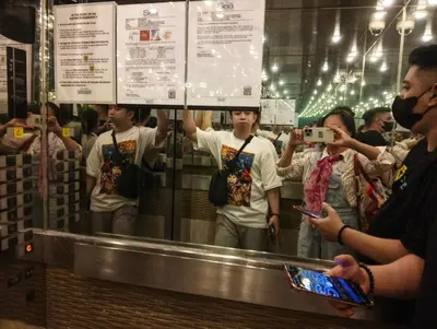 a group of people taking pictures in a store at Queen Pia Condotel in Manila