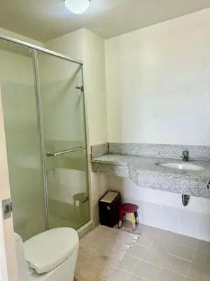 a bathroom with a shower and a toilet and a sink at Vacation at Munti in Manila
