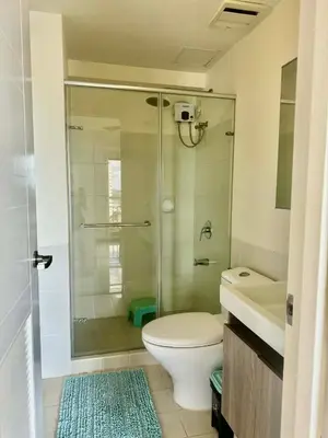 a bathroom with a shower and a toilet and a sink at Vacation at Munti in Manila