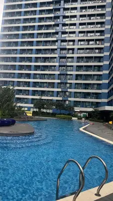 a swimming pool in front of a large building at Snooze & Stay in Manila