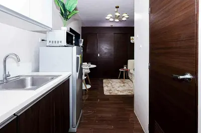 a kitchen with a sink and a refrigerator at Snooze & Stay in Manila