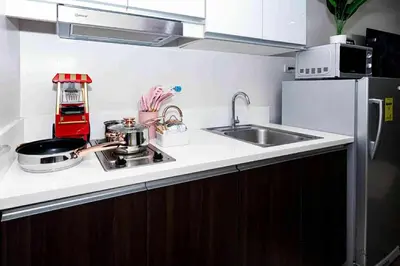 a kitchen counter with a sink and a microwave at Snooze & Stay in Manila