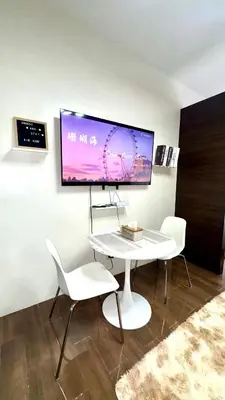 a white table with two chairs and a tv on a wall at Snooze & Stay in Manila