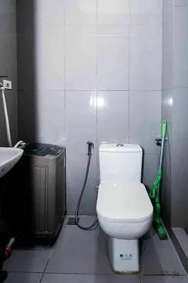 a bathroom with a white toilet and a sink at Snooze & Stay in Manila