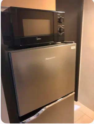 a microwave sitting on top of a refrigerator at Entire 2BR apartment in BGC in Manila