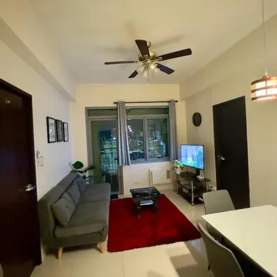 a living room with a couch and a ceiling fan at Entire 2BR apartment in BGC in Manila