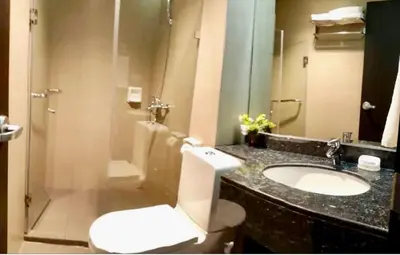 a bathroom with a white toilet and a sink at Entire 2BR apartment in BGC in Manila