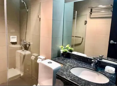 a bathroom with a sink and a toilet and a shower at Entire 2BR apartment in BGC in Manila