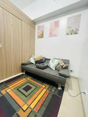 a living room with a couch and a rug at H&M condotel in Manila