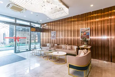 a lobby with a couch and two tables and chairs at Luna Hotel by RedDoorz near MOA in Manila