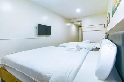 a hospital room with two beds and a tv at Luna Hotel by RedDoorz near MOA in Manila
