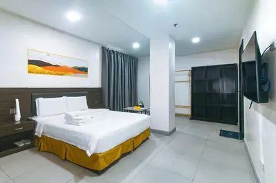 a hotel room with a bed and a television at Luna Hotel by RedDoorz near MOA in Manila