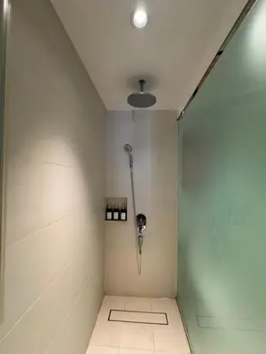 a shower in a bathroom with white walls at Hotel Residence at Novotel in Manila