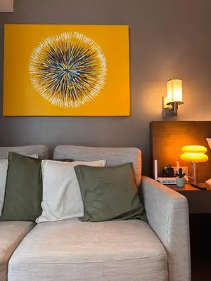 a living room with a couch with a firework painting at Hotel Residence at Novotel in Manila