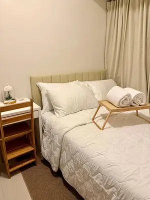 a bedroom with a bed with a table on it at 1 Bedroom Near Mall of Asia in Manila