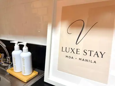 a sign in a window with two bottles on a sink at 1 Bedroom Near Mall of Asia in Manila
