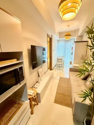 a living room with a couch and a tv at 1 Bedroom Near Mall of Asia in Manila