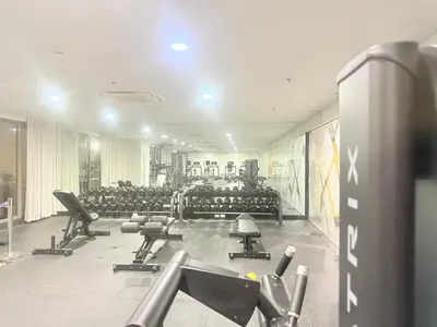 a gym with rows of exercise equipment in a building at 1 Bedroom Near Mall of Asia in Manila