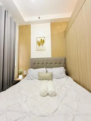 a large white bed with two white towels on it at MC Haven Staycation near MOA in Manila