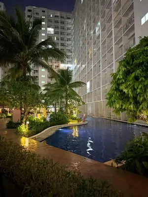 a swimming pool in front of a building at night at MC Haven Staycation near MOA in Manila