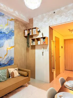 a living room with a couch and a painting on the wall at MC Haven Staycation near MOA in Manila