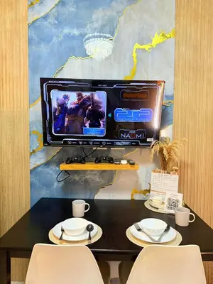 a table with two chairs and a tv on a wall at MC Haven Staycation near MOA in Manila