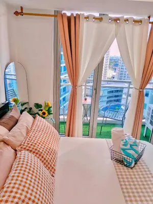 a bedroom with a bed and a large window at Vacation in Harmony in Manila