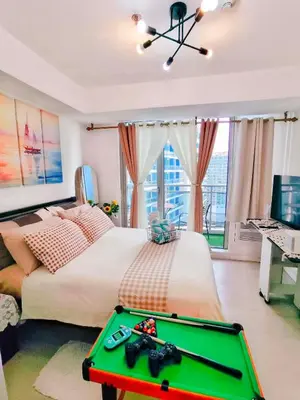 a bedroom with a bed with a pool table at Vacation in Harmony in Manila