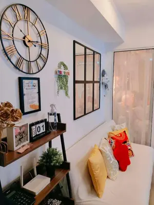 a living room with a white couch with a clock on the wall at Vacation in Harmony in Manila