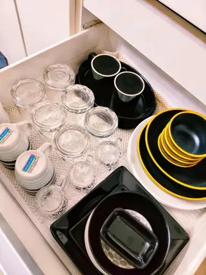 a drawer filled with plates and glasses and a table at Vacation in Harmony in Manila