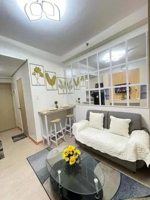 a living room with a couch and a glass table at Transient Home Lancin in Manila
