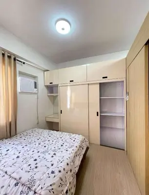 a small bedroom with a bed and a closet at Transient Home Lancin in Manila