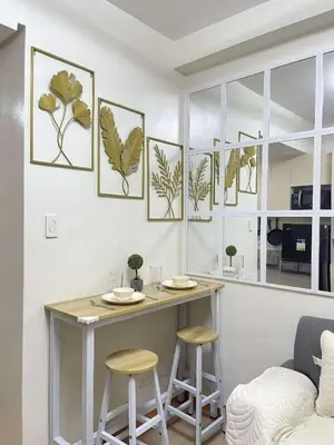 a dining room with a table and stools at Transient Home Lancin in Manila