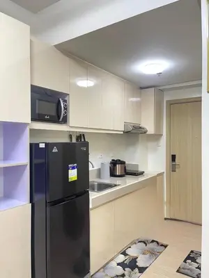 a kitchen with a black refrigerator and a sink at Transient Home Lancin in Manila