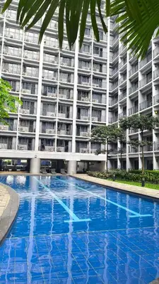 a large apartment building with a large blue swimming pool at Urban Haven Manila in Manila