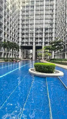 a large swimming pool in front of a large building at Urban Haven Manila in Manila