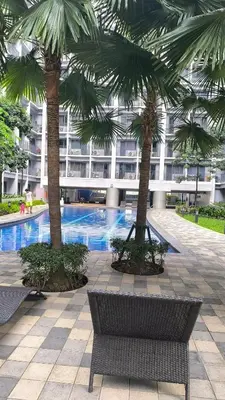 a courtyard with two palm trees and a building at Urban Haven Manila in Manila
