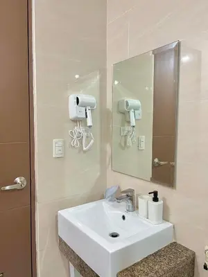 a bathroom with a white sink and a mirror at CONDOTEL - Across NAIA T3 Airport with WIFI in Manila