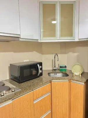 a kitchen with a microwave and a sink at CONDOTEL - Across NAIA T3 Airport with WIFI in Manila