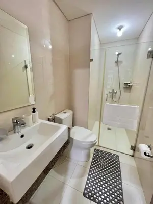 a white bathroom with a sink and a toilet at CONDOTEL - Across NAIA T3 Airport with WIFI in Manila