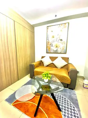 a living room with a couch and a glass table at Jay's Staycation at Shore Residences Pasay in Manila
